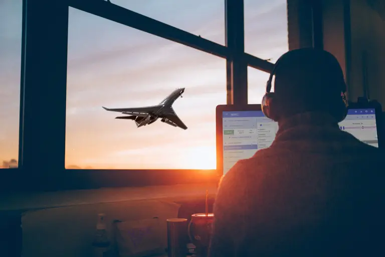 Schedule planner working, with business jet taking off at sunset in the background